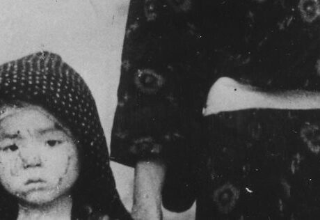 A Japanese toddler walks next to her grandmother. She seems in shock.