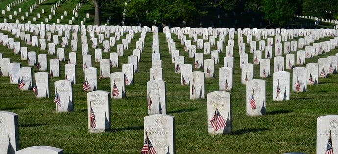 A cemetery with many neatly lined tombstones.